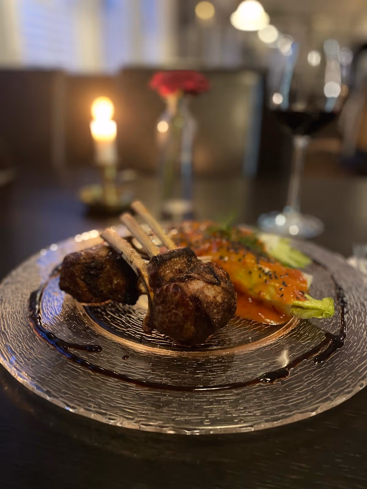 Hauptgericht mit Fleisch, angerichtet bei Kerzenschein.