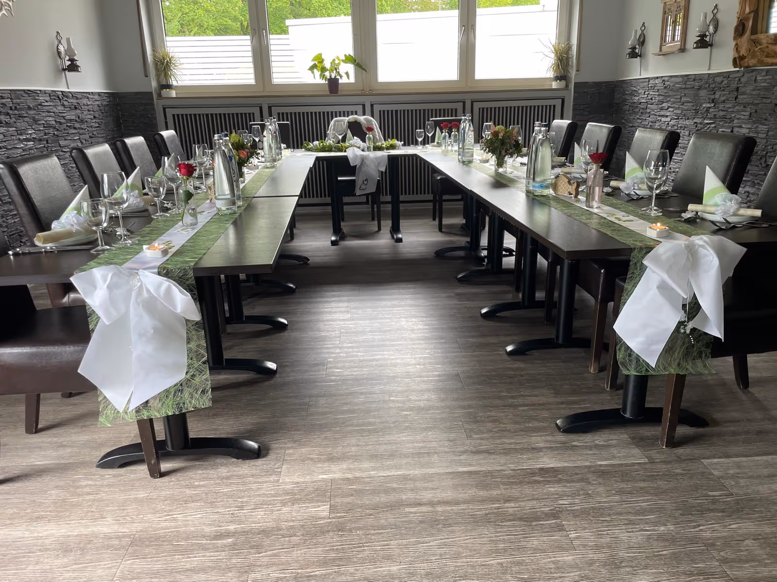 Blick auf elegant gedeckte Tische mit weißen Stuhlhussen.