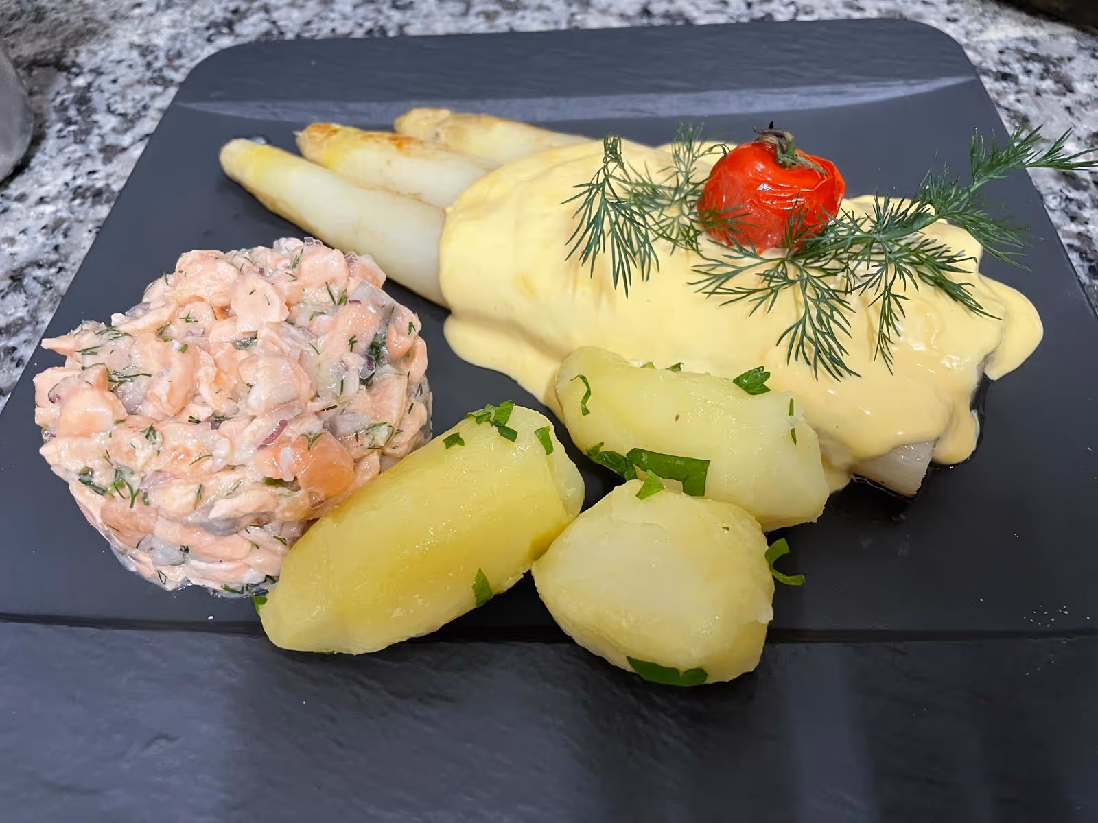 Fleischgericht mit Kartoffeln und Gemüse, auf einem Teller angerichtet.