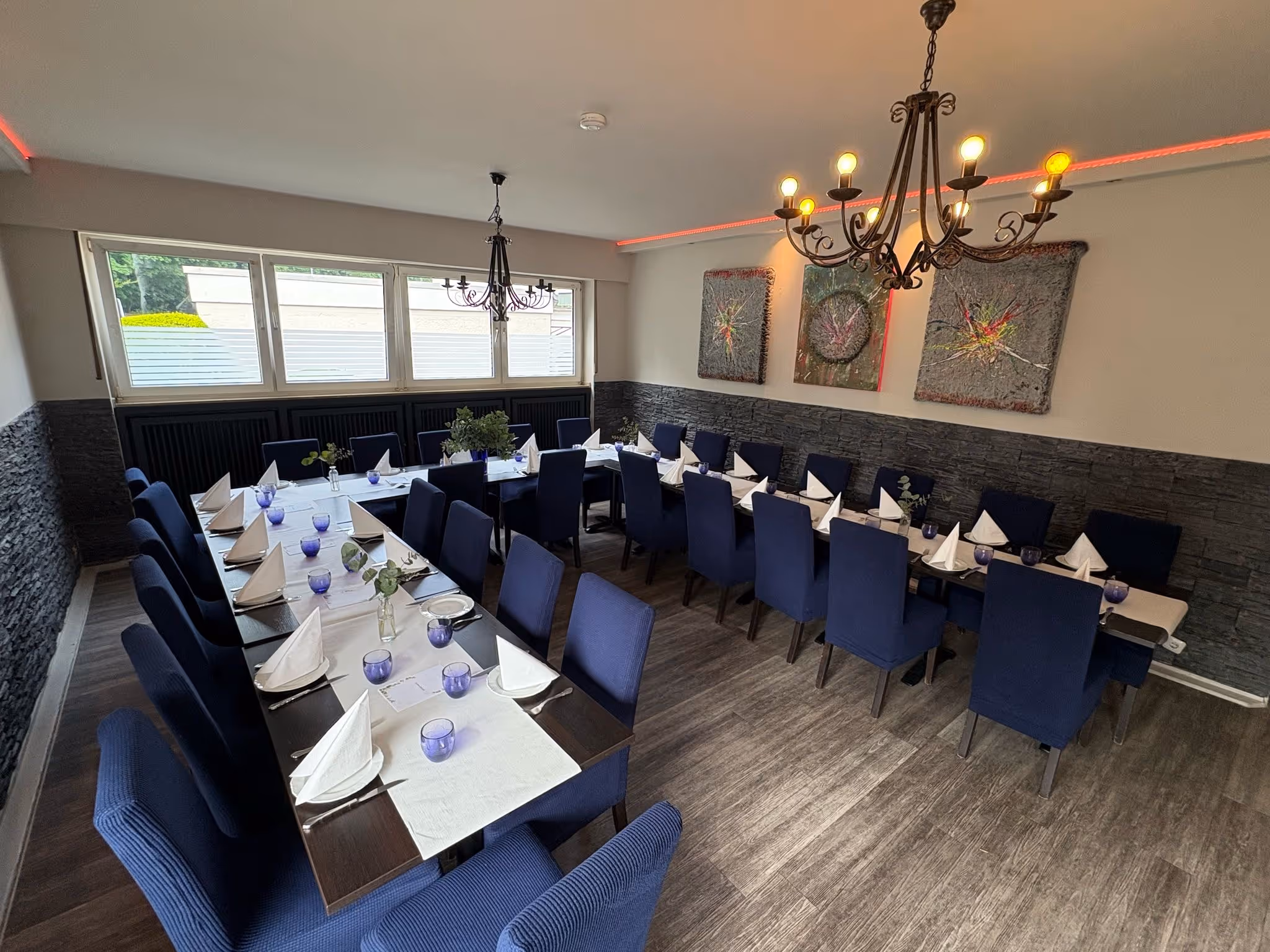 Festlich gedeckter Tisch in einem Restaurant mit weißen Stuhlhussen.